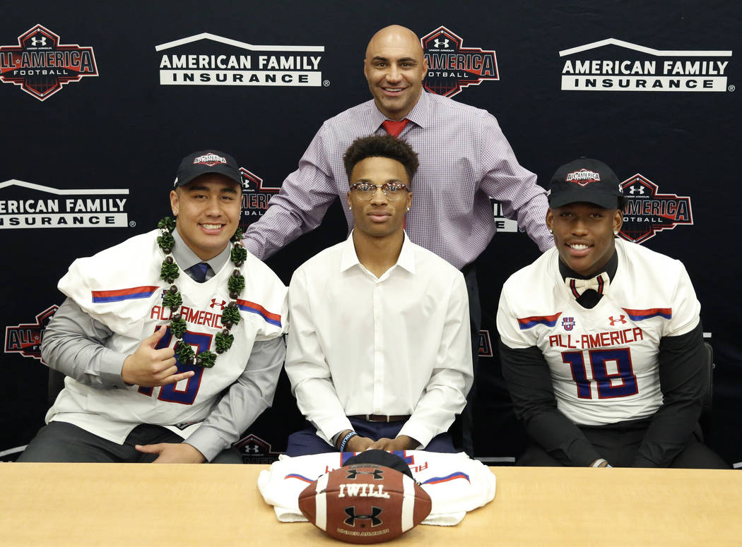 Bishop Gorman’s head coach Kenny Sanchez, standing, with offensive guard Jacob Isaia, ...