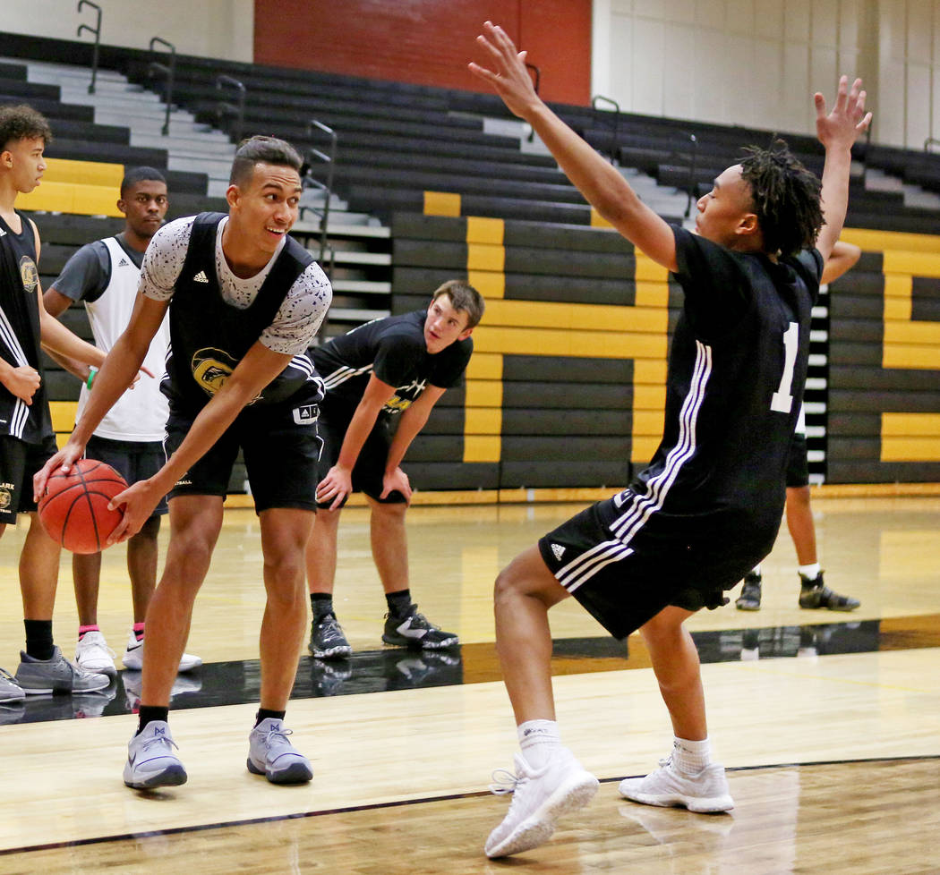 Clark High School senior Greg Foster prepares to pass the ball while Frank Collins guards du ...