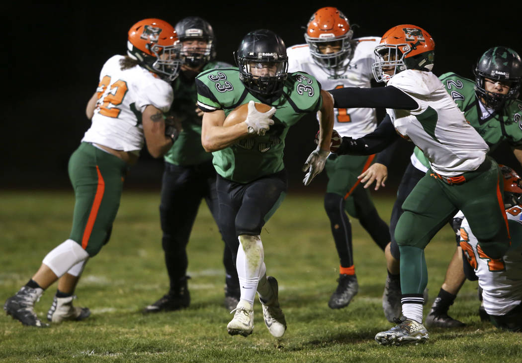 Virgin Valley’s Jayden Perkins (33) gets through Mojave defenders during the Class 3A ...