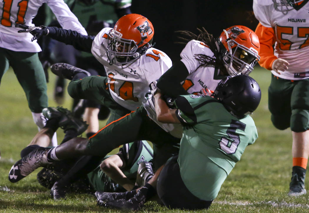 Mojave’s Noah Thompson (10) is tackled by Virgin Valley’s Carlos Pacheco (5) dur ...