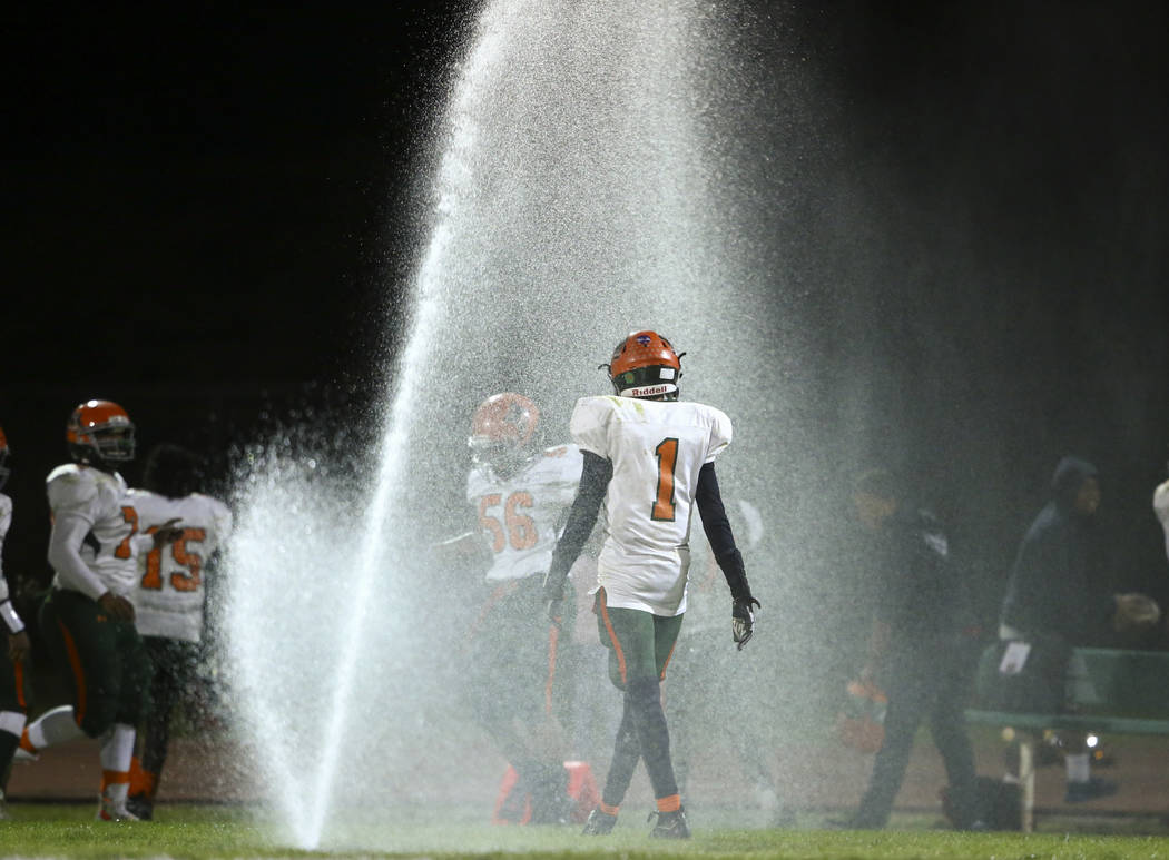 Mojave players walk in the water after sprinklers went off during the Class 3A state quarter ...