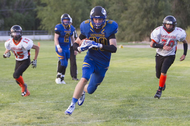 Pahranagat Valley Panthers tight end Culen Highbe, second right, runs the ball against Wells ...