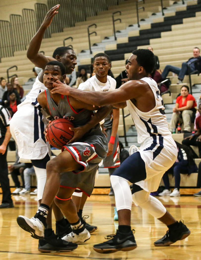 Arbor View’s Favor Chukwukelu (2), center, runs the ball as he is guarded by Democracy ...