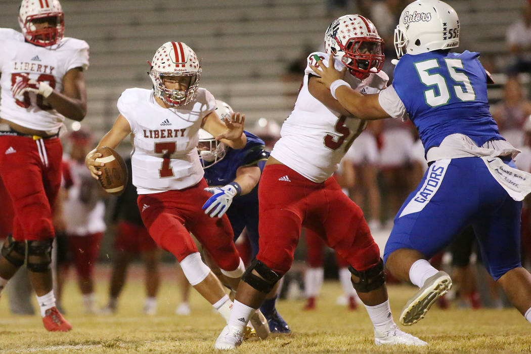 Liberty quarter back Kenyon Oblad (7) runs the ball during the first half of a game against ...