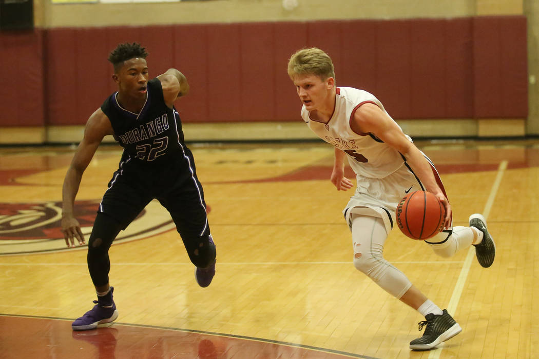Durango player Vernell Watts (22) trails after Desert Oasis player Jacob Heese (15) as he dr ...