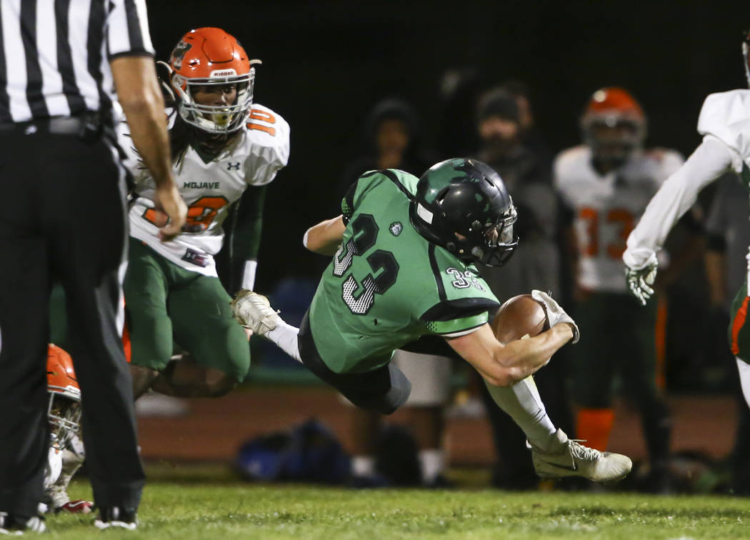 Virgin Valley’s Jayden Perkins (33) gets tripped up by Mojave during the Class 3A stat ...
