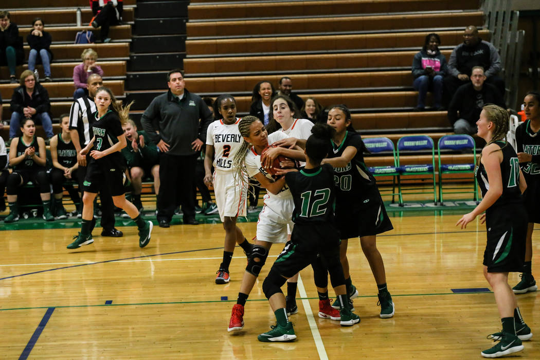 Beverly Hills’ Emma Duchemin (23) holds onto the ball as Green Valley’s Rian And ...