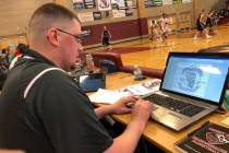 Desert Oasis assistant coach Dave Aikman working on his computer during the Tri-State Invita ...