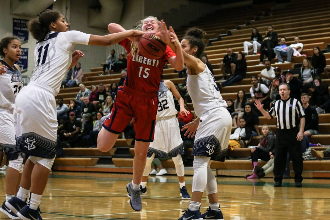 Liberty’s London Pavlica (15) is blocked by Spring Valley’s Kayla Harris (11) a ...