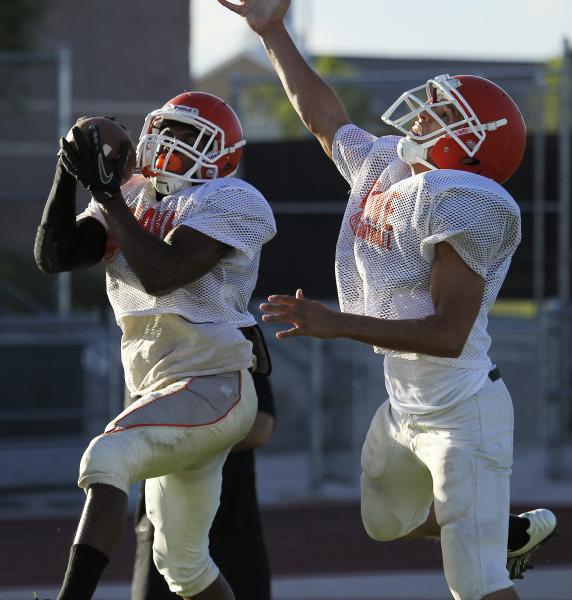Mojave junior running back Ty Flanagan, left, catches a pass during a recent practice. Flana ...