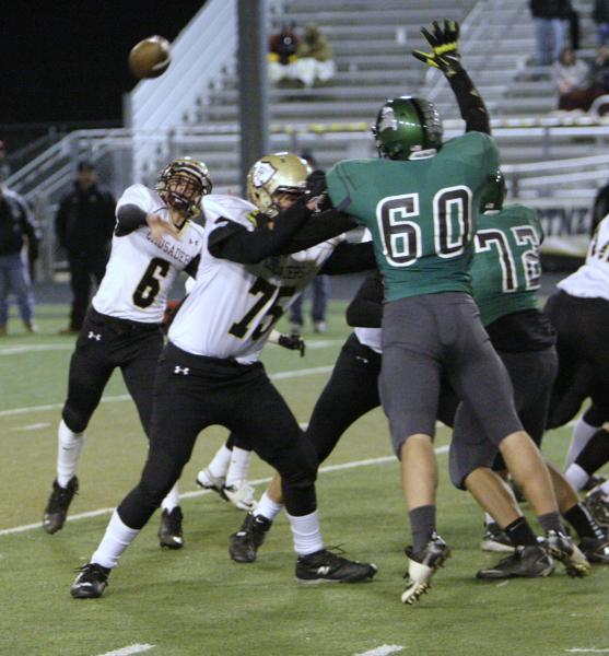 Faith Lutheran quarterback Jacob Deaville (6) unloads a pass as teammate Austin Prather (75) ...