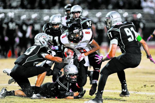 Las Vegas receiver Corey Sinceno (8) is brought down by a host of Green Valley defenders inc ...