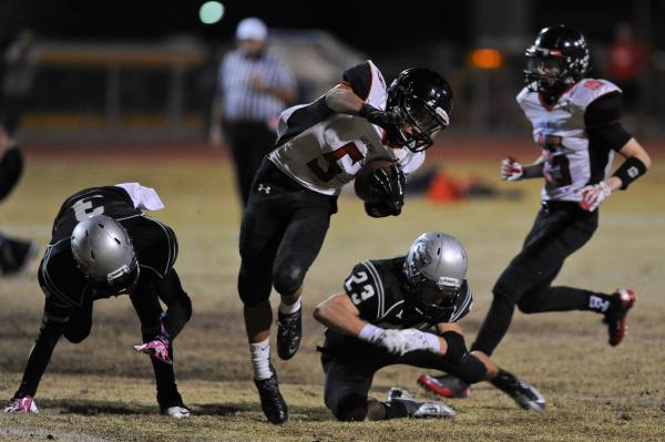 Las Vegas running back Andrew Moreland (5) tiptoes between Green Valley’s Jacob Tomlin ...