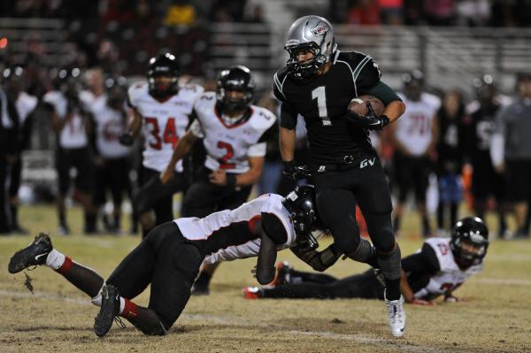 Green Valley’s Giovanni Hernandez (1) breaks an attempted tackle by Las Vegas defender ...