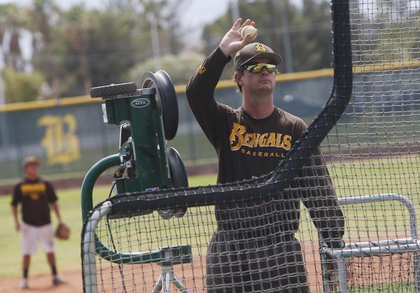 Bonanza baseball coach Derek Stafford feeds baseballs into a pitching machine at practice Tu ...