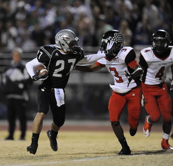 Green Valley’s Markus Varner (27) delivers a stiff-arm to Las Vegas’ Jordan Jone ...