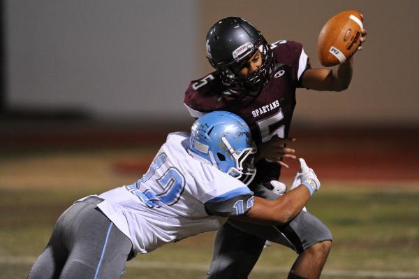 Cimarron’s Derek Morefield (5) is wrapped up by Centennial’s Izaias Jackson (12) ...