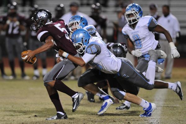 Cimarron’s Derek Morefield (5) is brought down by a host of Centennial defenders inclu ...