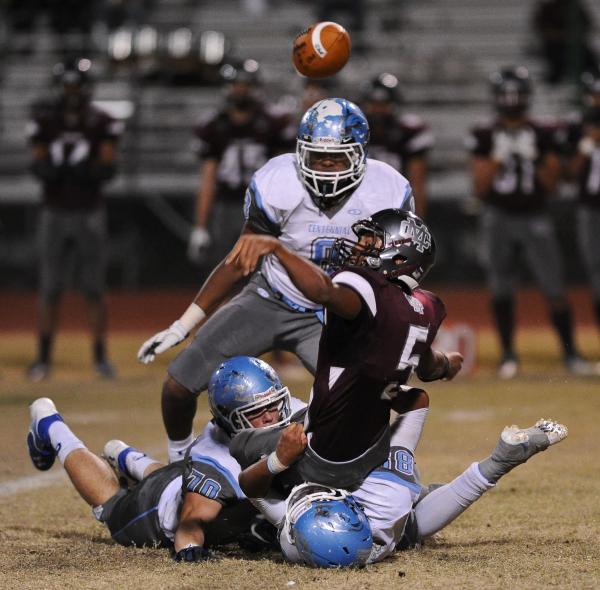 Cimarron’s Derek Morefield (5) loses the ball after being tackled by Centennial defend ...