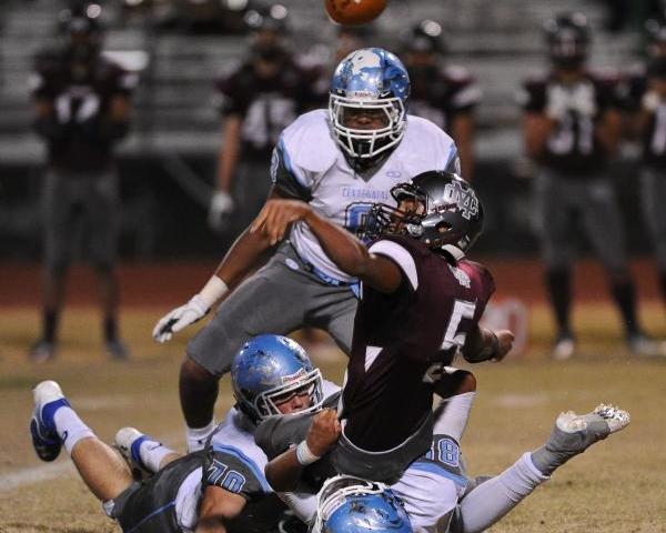 Cimarron’s Derek Morefield (5) loses the ball after being tackled by Centennial defend ...