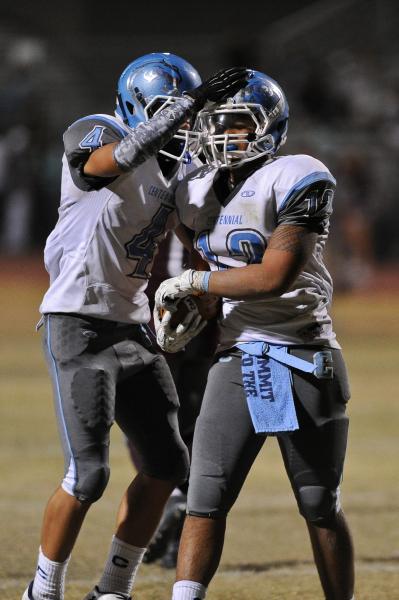 Centennial’s Izaias Jackson (12) is congratulated by Nicholas Humenik after an interce ...