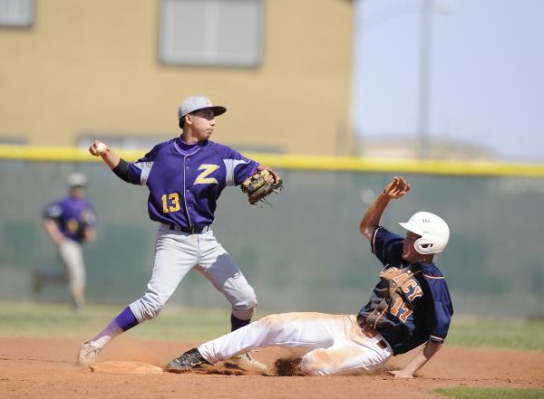 Durango shortstop Enrique Mesa tries to make a throw as Legacy’s Brad Blackham slides ...