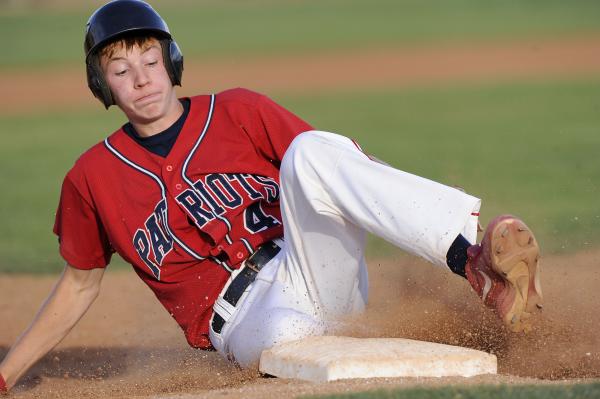 Liberty shortstop James Martz slides into third base after hitting a triple in the fifth inn ...