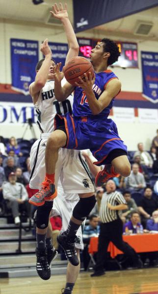 Gorman’s Noah Robotham (14) goes up for a basket while being guarded by Sheldon’ ...