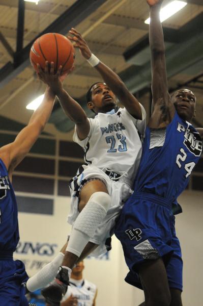 Canyon Springs guard Shaquile Carr (23) tries to score around Desert Pines forward ...