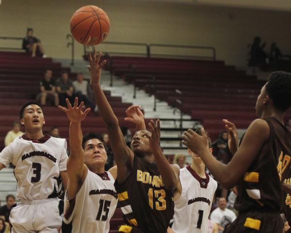 Bonanza’s Jamal Logan (13) shoots while surrounded by Desert Oasis’ Austin Vasqu ...