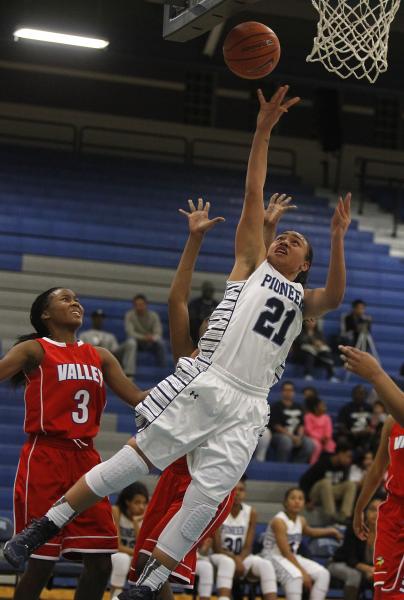 Canyon Springs’ Trimece Thomas (21) scores in front of Valley’s Alaihya Williams ...