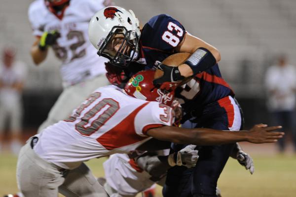 Coronado receiver Brian Johnson (83) is wrapped up by Arbor View defender C.J. Smith (30) on ...