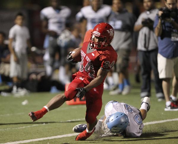 Arbor View running back Herman Gray is tripped up by Centennial defensive back Samuel Liaga ...