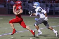 Arbor View running back Ricky Clark runs ahead of Centennial defensive back Samuel Liaga for ...