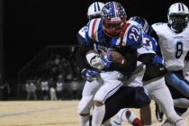 Patriots wide receiver Deseon McQuaig (22) is tackled down by Canyon Springs defenders on Fr ...