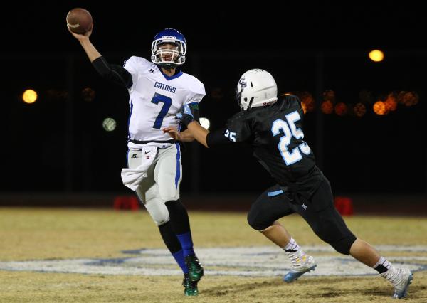 Green Valley’s Christian Lopez throws a pass while Canyon Springs’ Ezekial Lopez ...