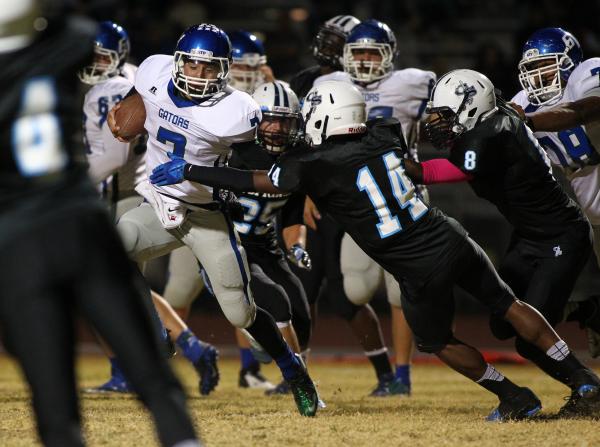 Green Valley’s Christian Lopez tries to elude Canyon Springs’ Jaquan Ashley (14) ...