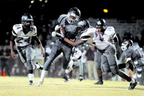 Legacy’s Casey Hughes, center, runs for one of his three touchdowns on Friday against ...