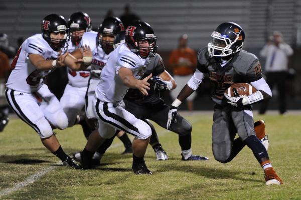 Legacy running back DeMichael Walker (22) runs past a host of Hurricane defenders on Saturda ...