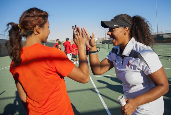 Hannah Tatlock, right, who helps coach the Mojave girls tennis team, encourages Nattaporn Th ...