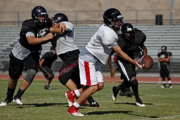 Las Vegas quarterback Trevor Swenson hands the ball off during Tuesday’s practice.
