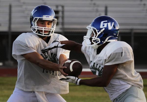Green Valley quarterback Christian Lopez hands the ball off during practice. Lopez and the G ...