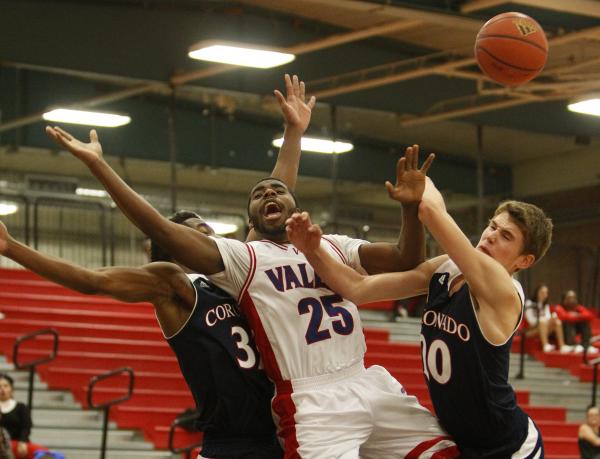 Gerard Harden of Valley High School, center, gets fouled by KeDean Toney of Coronado on Wedn ...