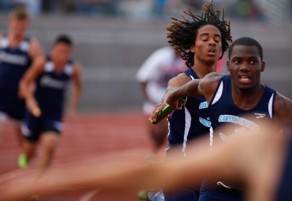 Canyon Springs runners pass the baton during the Sunrise Region 800-meter relay on Friday. T ...