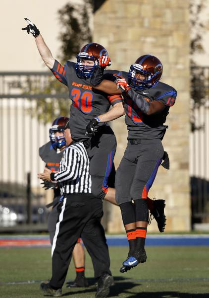 Dylan Weldon (30) of Bishop Gorman celebrates with teammate Armand Perry (13) after one of W ...