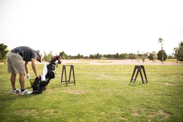 Desert Oasis golf team member Syouta Wakisaka gets tees out of his bag during practice at Pa ...