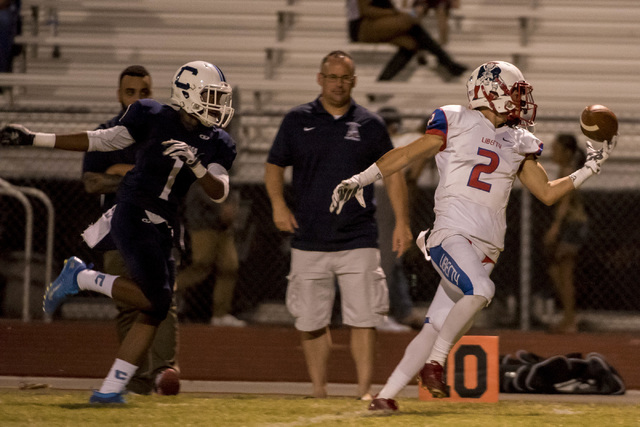 Liberty Patriots wide receiver Ethan Dedeaux (2) bobbles the ball as Centennial Bulldogs def ...