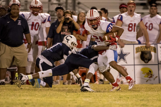Centennial Bulldogs defensive back JJ Johnson (12) tackles Liberty Patriots wide receiver Da ...