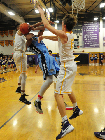 Centennial guard Troy Brown (0) goes up for a shot while being defended by Durango forwards ...