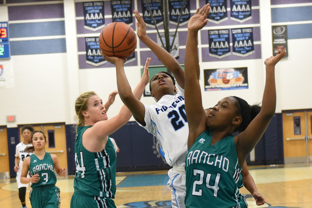 Canyon Springs Alexa Thrower (20) goes up for a shot against Rancho defenders Samantha Pocho ...